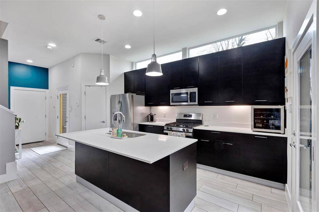 Stylish and functional – this kitchen features a spacious island for prep work and ample cabinetry for all your storage needs. The door beside the fridge leads to a spacious walk-in pantry
