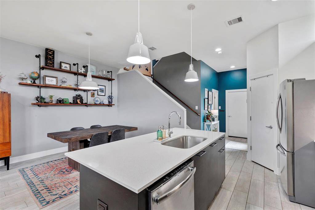 Get a closer look at this quartz kitchen island, beautifully lit with drop lights above, with the dining area just in front for easy convenience.