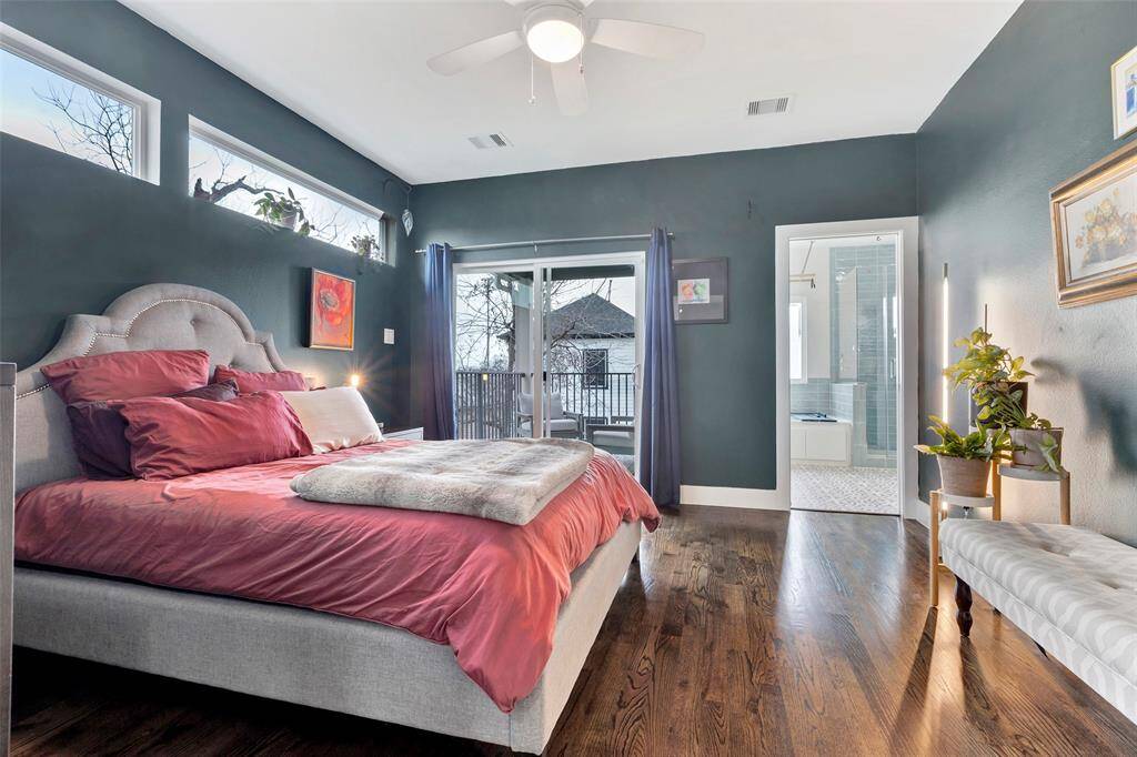 The serene primary bedroom, beautifully brightened by large glass doors and windows, creating a peaceful and airy retreat.