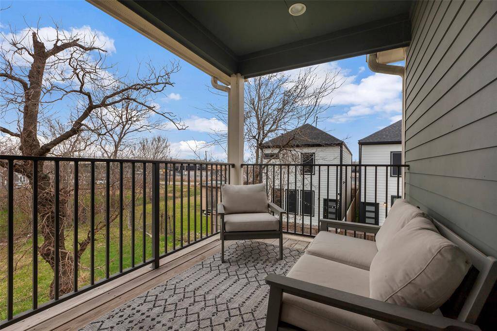 Enjoy the view from the second-floor balcony, featuring elegant iron railings and a beautiful overlook of the backyard and neighborhood.