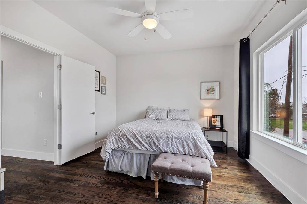This secondary bedroom on the second floor boasts large glass windows and hardwood floors, ready for you to personalize and make it your own. Enjoy a walk-in closet for additional storage.