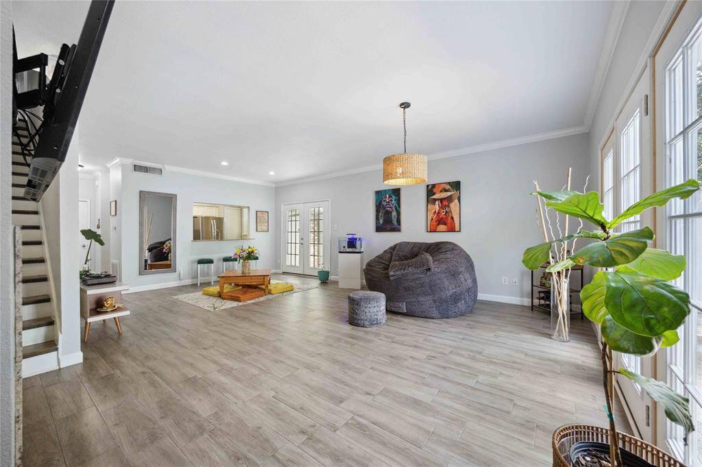 Spacious living/dining area with abundance of natural light. Stairs access to 2nd floor and kitchen at the end.