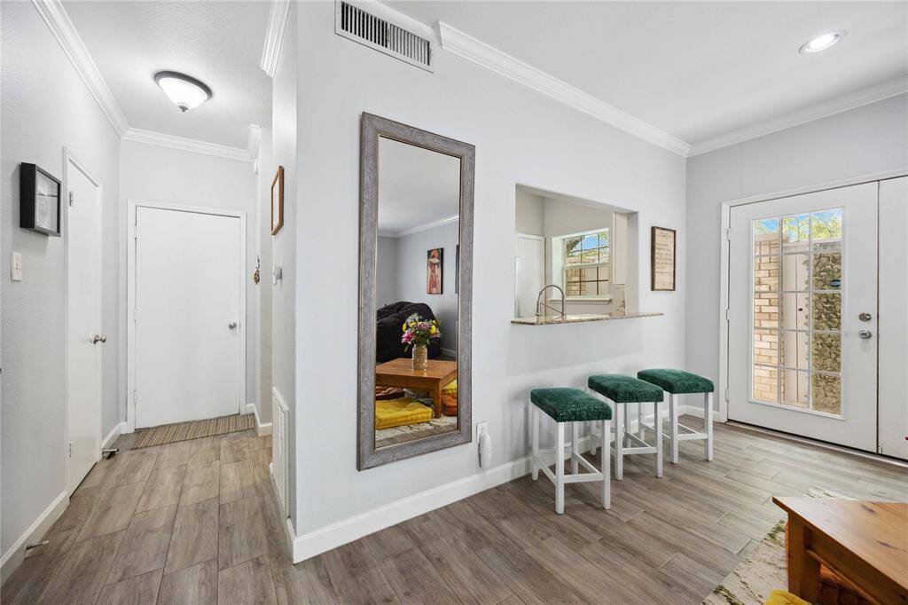 View of kitchen from the living area with breakfast bar and garage access.