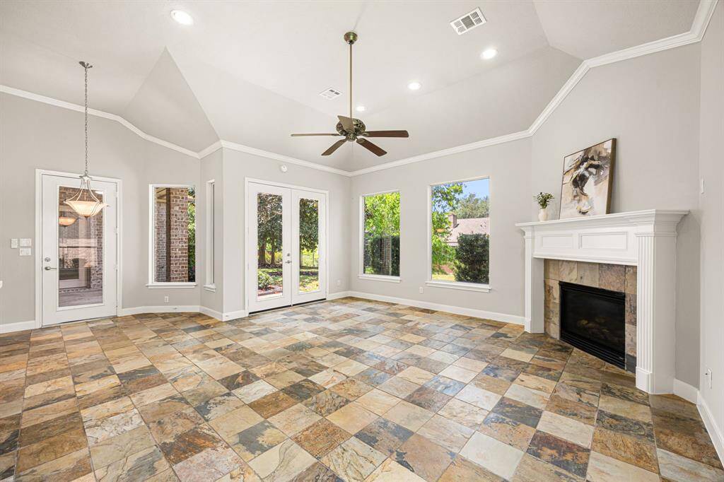 The Family Room is beautiful, featuring slate flooring, lots of windows, including double butted windows, a gas log fireplace with a white mantel surround, fresh paint on the walls and ceiling, and soaring 11-foot ceilings, all offering stunning views of the gorgeous backyard. A glass door leads to the Backyard, adding easy access to outdoor living.