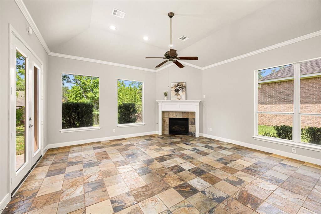 This angle gives you a closer look at the Fireplace with a slate tile surround and a designer ceiling fan, adding style and comfort to the space.