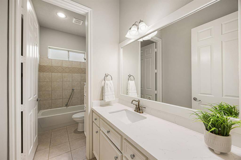 This Full Bathroom serves a dual purpose—accommodating both the Bedroom shown in the previous photo and your guests. It features a Quartz countertop, undermount sink, satin nickel faucet and light fixture, newly painted cabinets and a tub/shower combination.