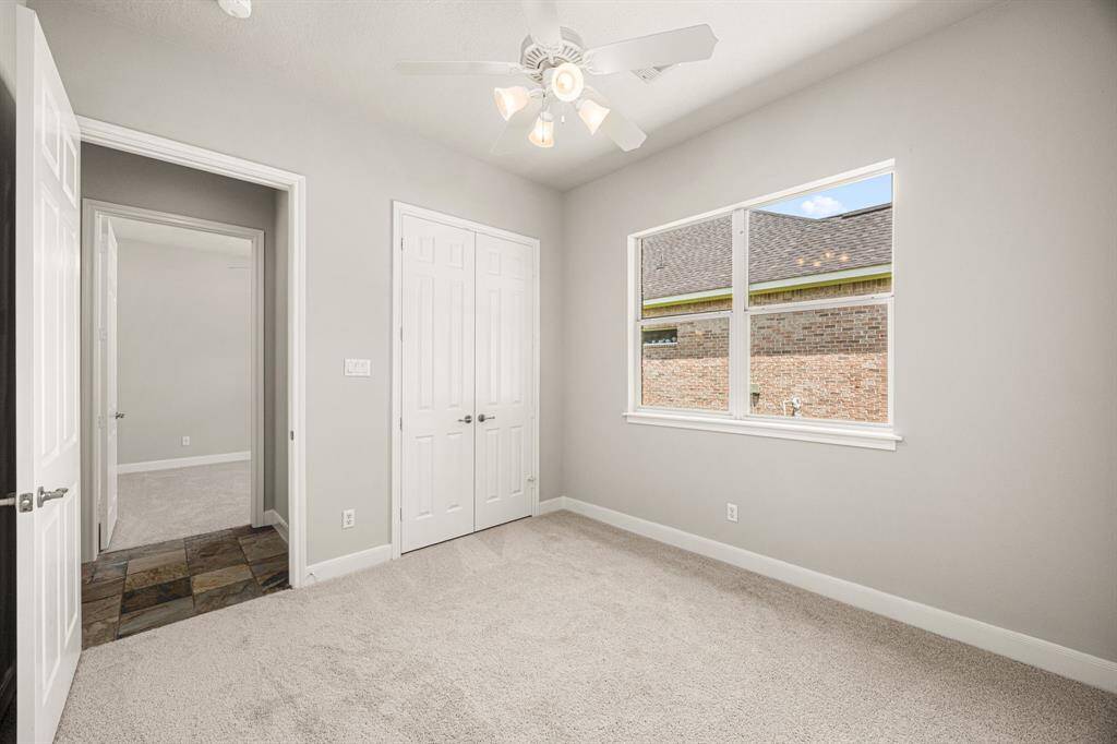 Another Secondary Bedroom features newly installed carpet, fresh paint, a large window for natural light, a ceiling fan for added comfort, and a double-door closet.