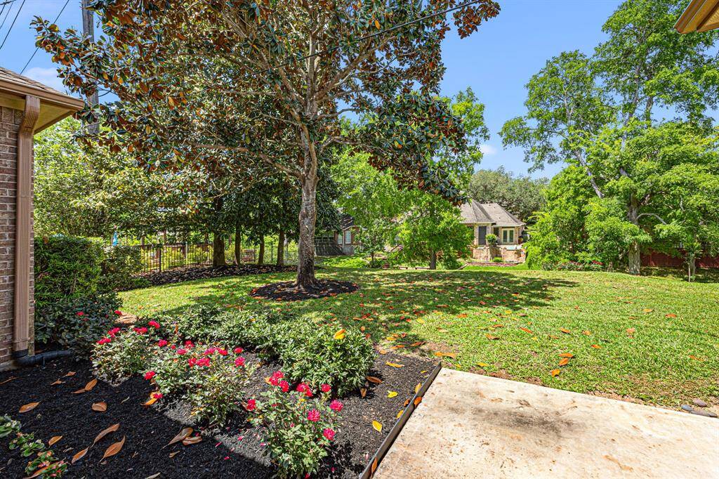 The Backyard gently slopes down to Pecan Lake, surrounded by mature trees, creating a serene and private retreat.