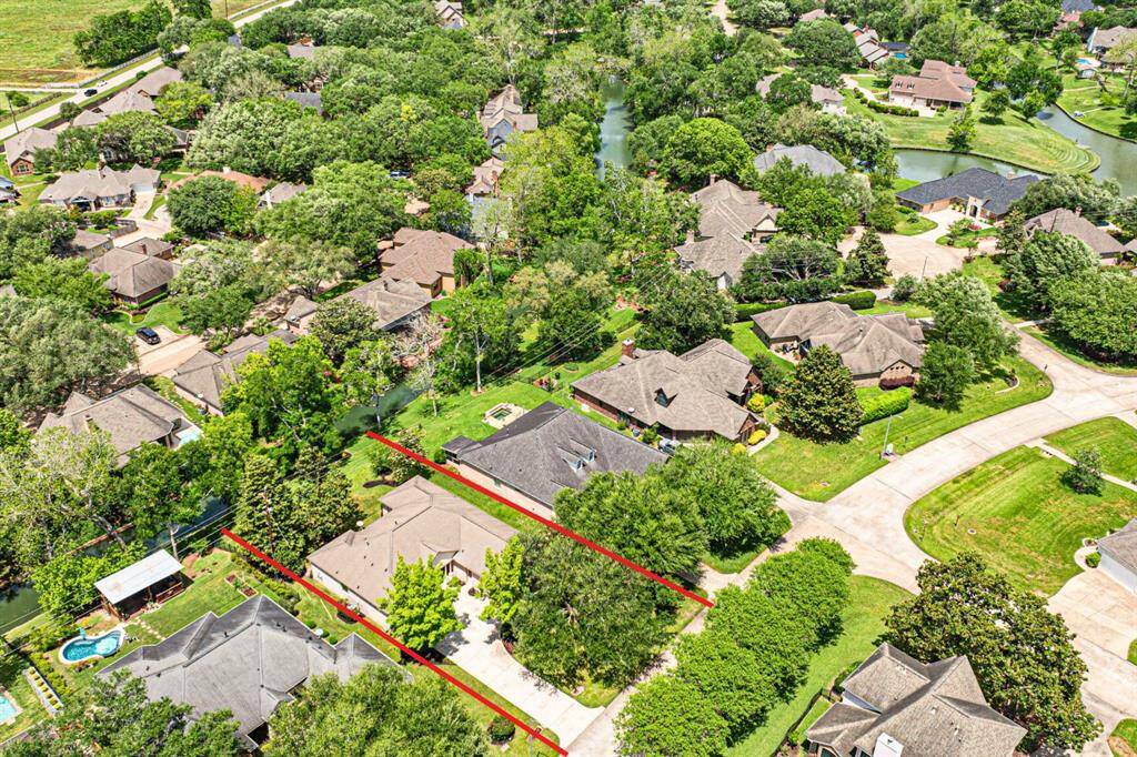A bird's-eye view shows the entire property, highlighting the layout and surrounding landscape. Notice how Pecan Lake meanders through this section of Weston Lakes, enhancing the serene and picturesque surroundings. The property lines are highlighted in red, though not exact, giving a general sense of the boundaries.