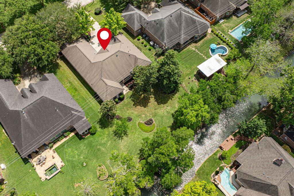 A closer look at the backside of the house, with Pecan Lake in the backdrop, highlighting the tranquil setting.