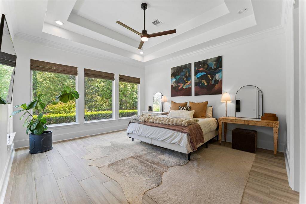 The primary suite itself features high ceilings and beautiful large windows that let in plenty of natural light and create an atmosphere that’s light, bright, and airy.