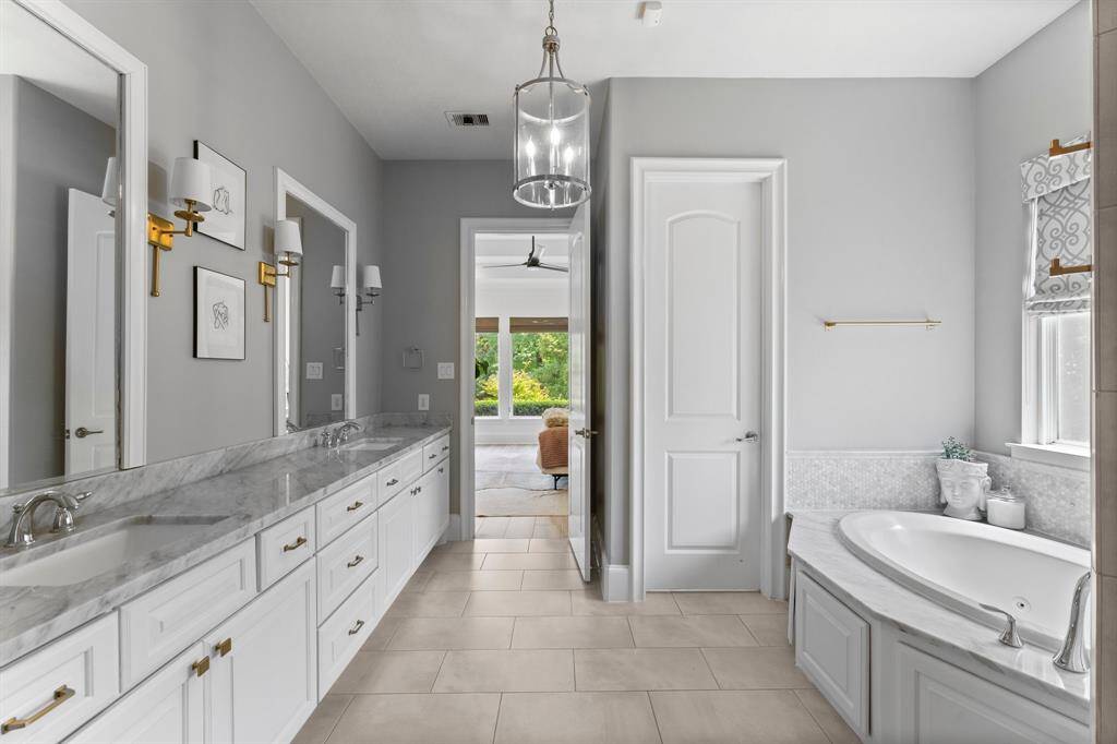 The primary bathroom is a spa-like sanctuary with dual vanities, a separate walk-in shower, and a garden tub.