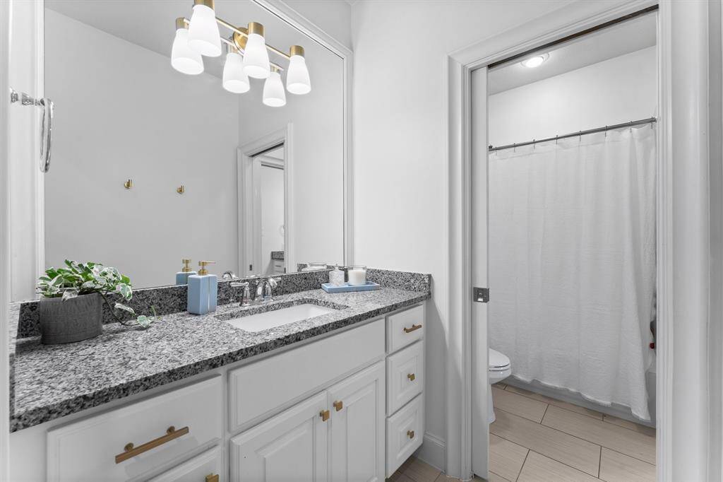 Full bath, sleek counters and modern lighting