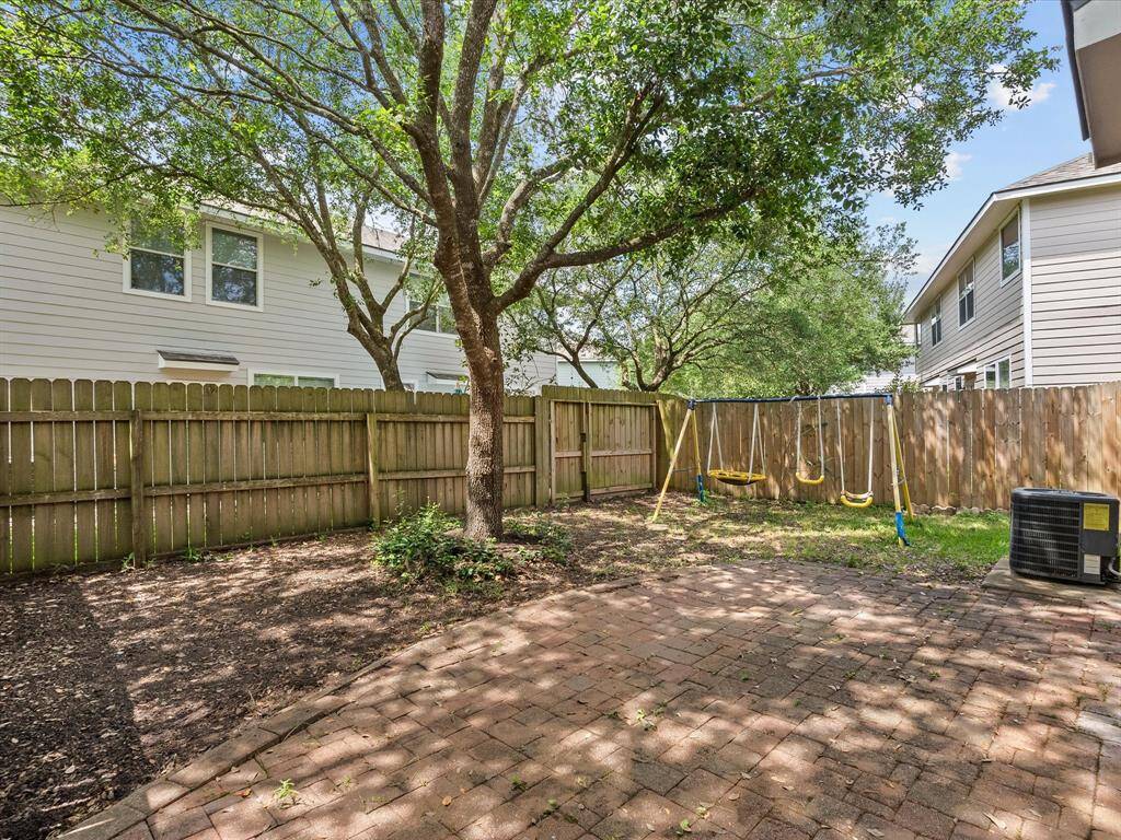 Fully fenced backyard with patio and mature trees.