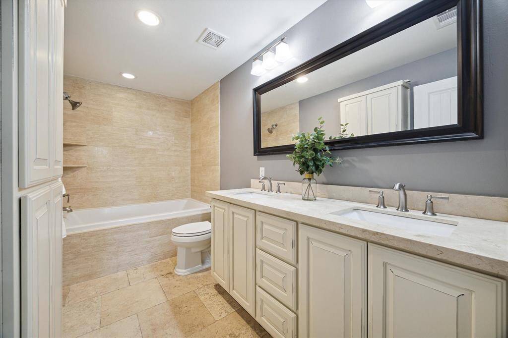 PRIMARY BATHROOM- Double sinks, shower/tub combo, and extra storage.