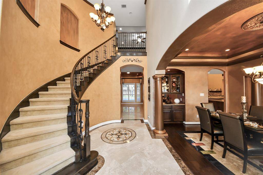 As you enter the home, you are greeted with a beautiful spiraling staircase