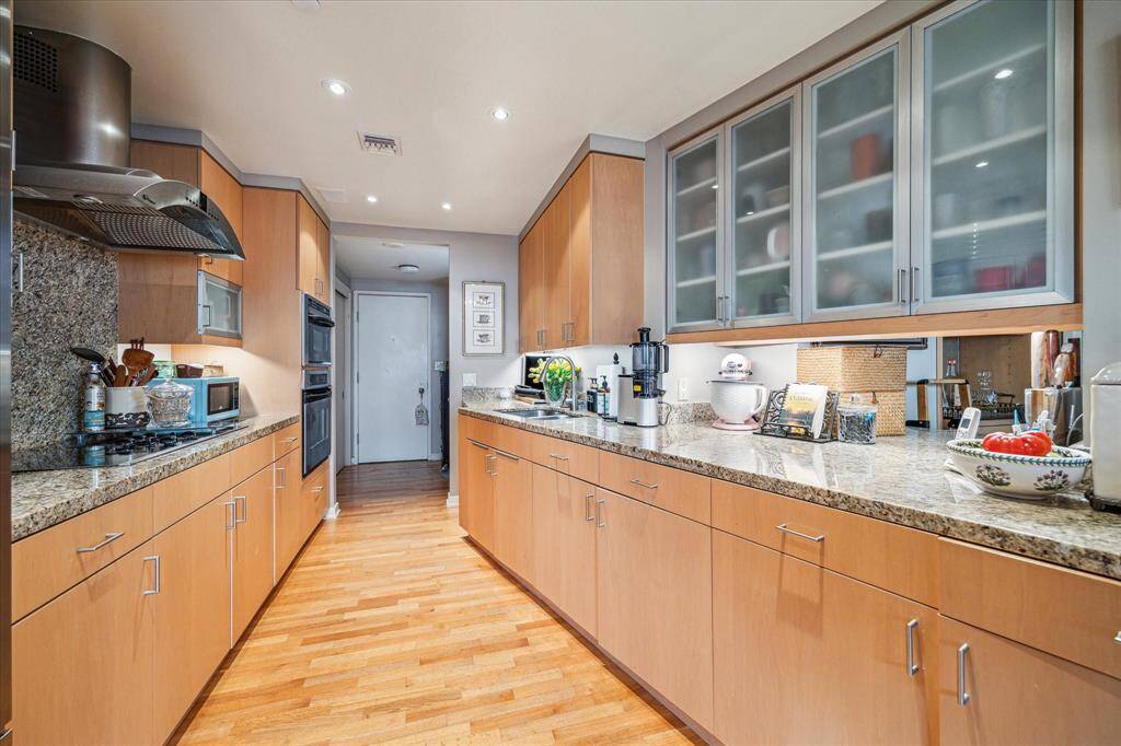 Wood floors, custom cabinets with under counter lighting and expansive granite counters meet a busy cook's dream.