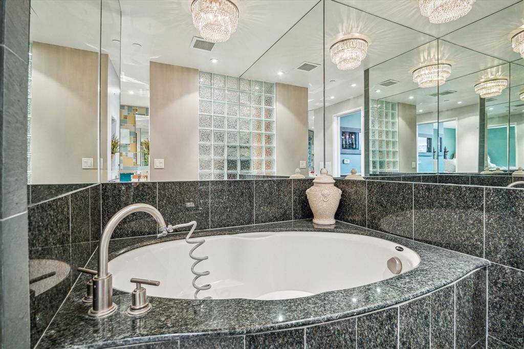 Spacious soaking tub with granite surround.
