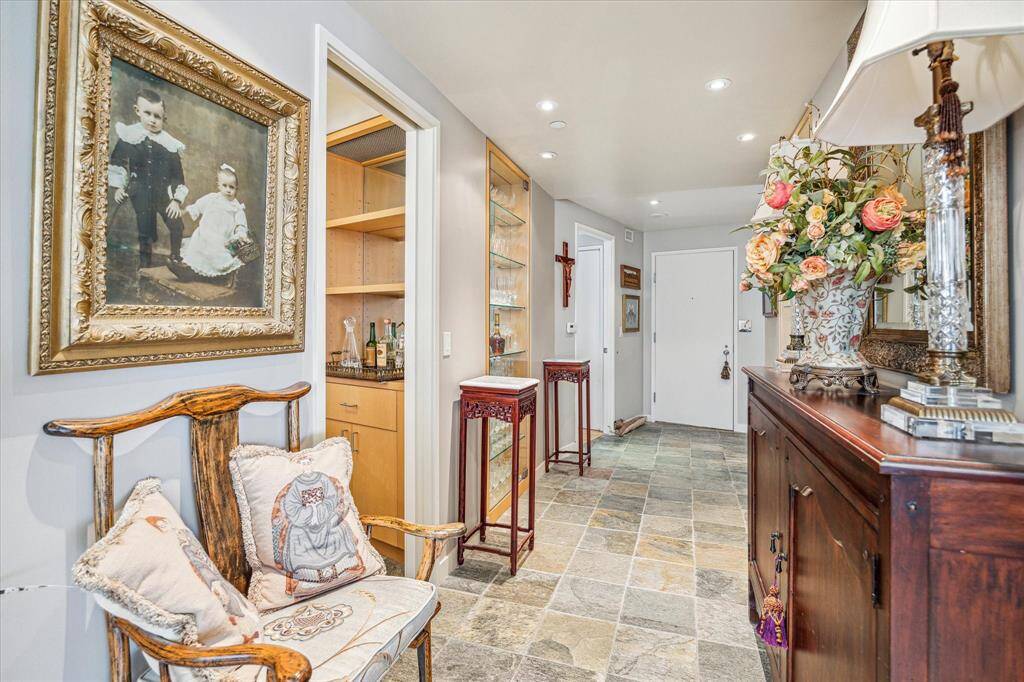 Looking from the living room toward the front door highlights the stone floors.