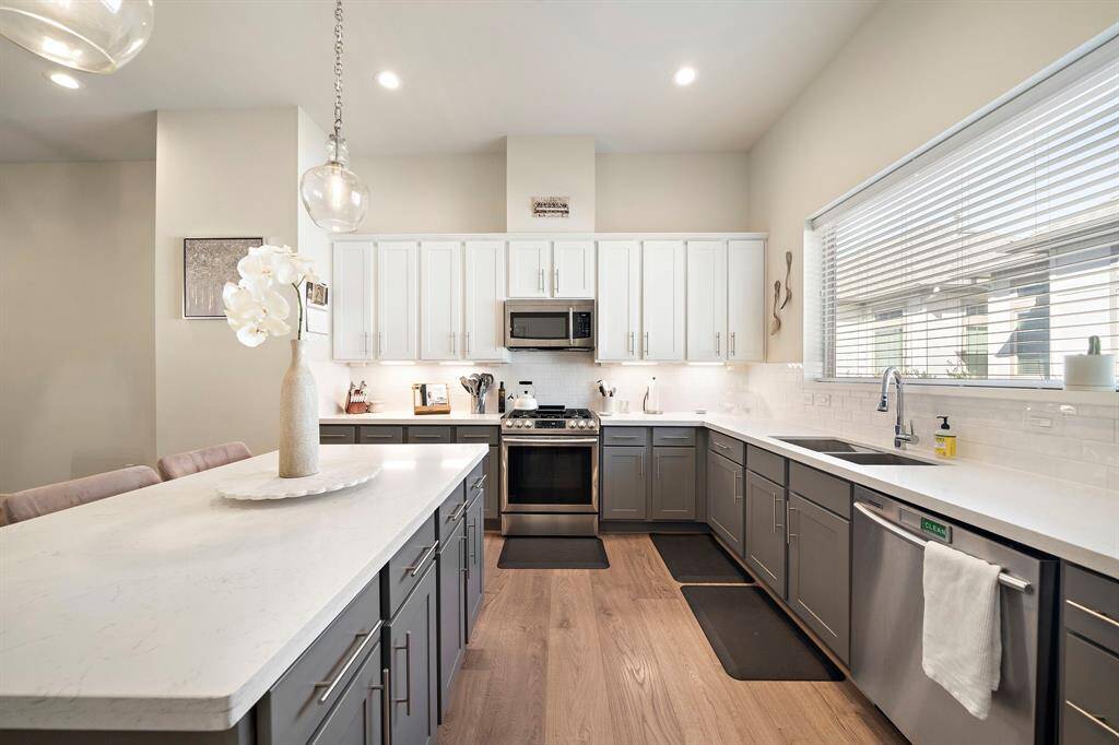 Bright and inviting kitchen with ample counter space, a generous sized island and upgraded pendant lighting