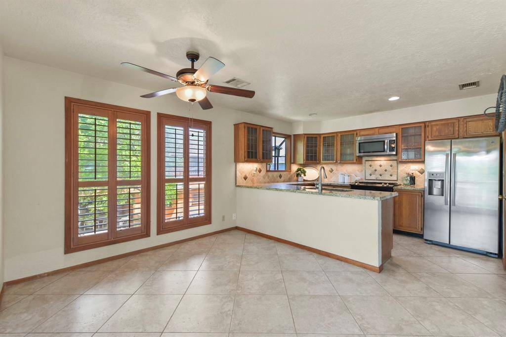 This kitchen boasts elegant granite countertops and stylish glass cabinets for a modern touch.