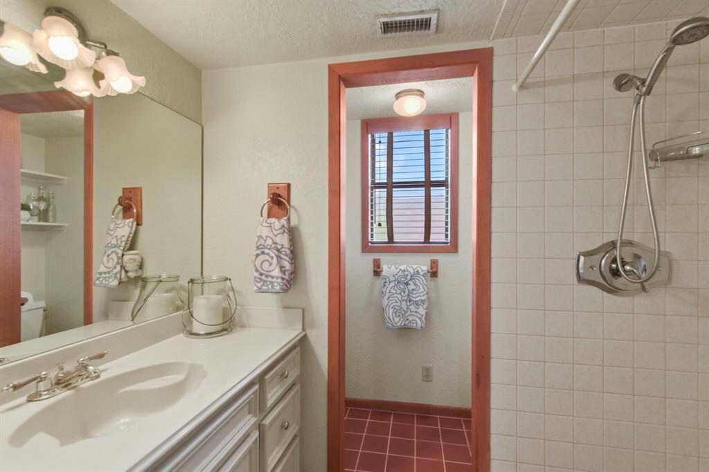 Spacious bathroom with elegant fixtures and ample lighting.