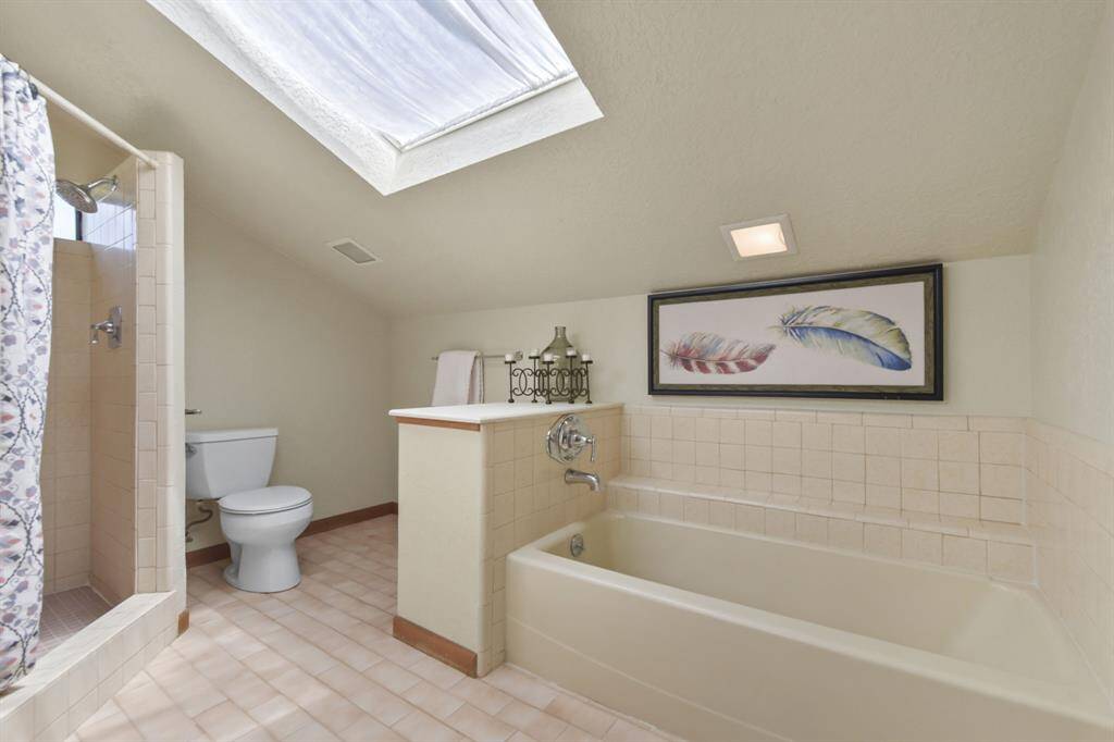 Discover a spacious walk-in closet conveniently located just across from the bathroom.