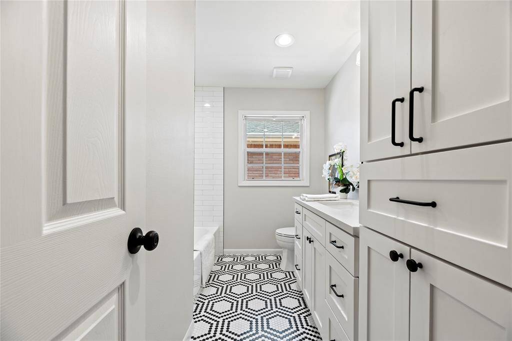 The  charming updated hall bath, with good storage, lovely tile floor.