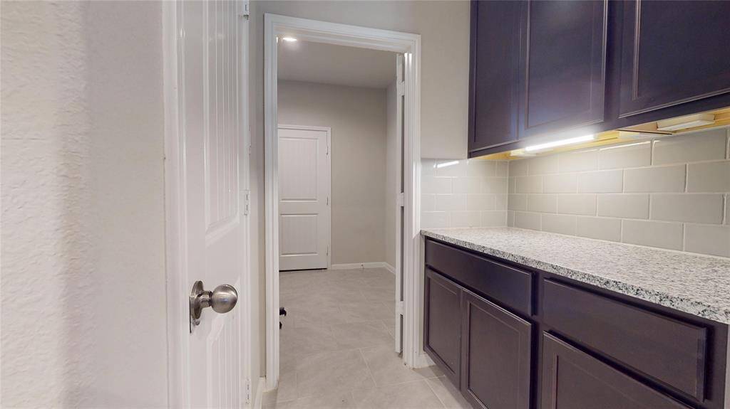 Additional prep area and storage between the kitchen and laundry room.   The door at left is the pantry.