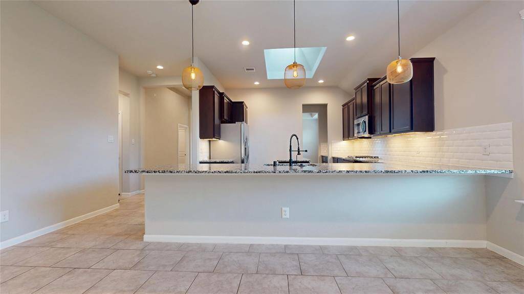 The kitchen peninsula has room for four or more seats. Notice the sky light in the middle of the kitchen.