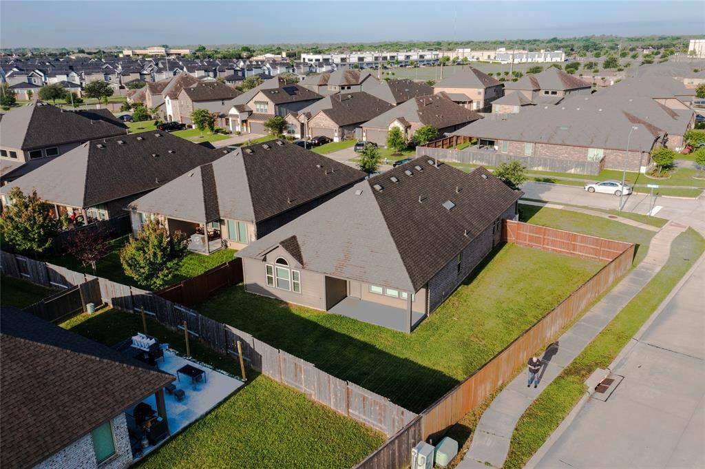 A view of the back and side yards, which are fully fenced and provide lots of space for entertaining and recreational activities.