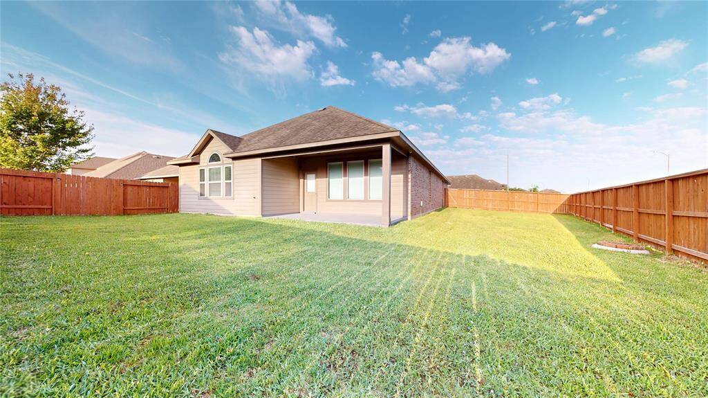 View looking from the rear of the property toward the back of the house.  Large back and side yards and covered porch offer many options for entertaining and recreational activities.