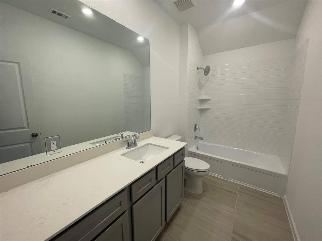 Spacious secondary bathroom with plenty of counter and storage space. There is also a linen closet in the hallway.