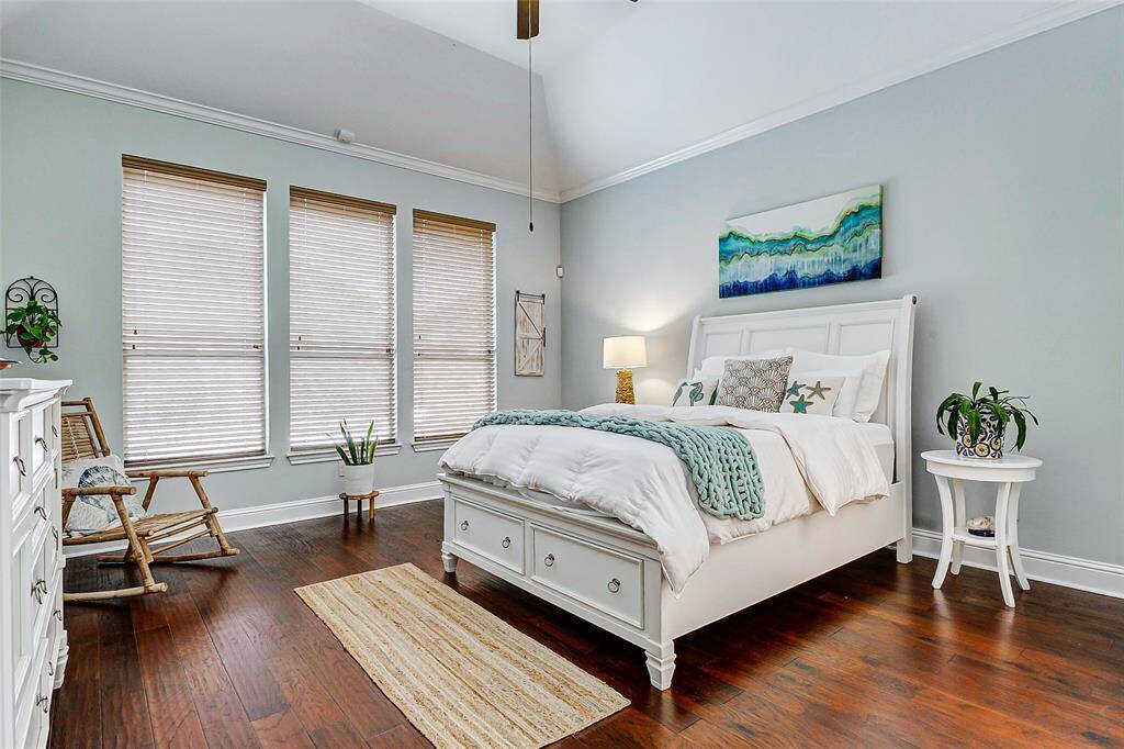 This spacious primary bedroom is a true haven of comfort, featuring large windows that frame beautiful outdoor views and allow natural light to pour in. The arched ceiling enhances the sense of space, adding an open and elegant touch. Rich wood flooring brings warmth and sophistication to the room, while the en suite bathroom offers added privacy and convenience, making this an ideal personal space.