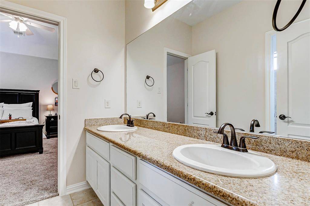 The secondary en suite bathroom features double sinks and an expansive vanity area with ample undercabinet storage. It’s a well-designed space that provides plenty of room for daily use while maintaining a clean and polished look.