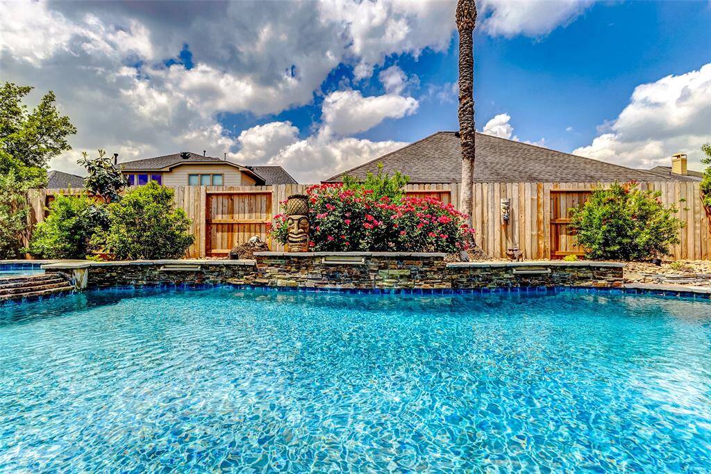 This outdoor haven is designed for both relaxation and entertainment, offering a resort-style experience right in your own backyard. The elevated spa flows seamlessly into the main pool, creating a stunning visual centerpiece that enhances the overall ambiance. The expansive space features covered seating and dining areas, perfect for al fresco dining or enjoying a quiet evening under the stars.