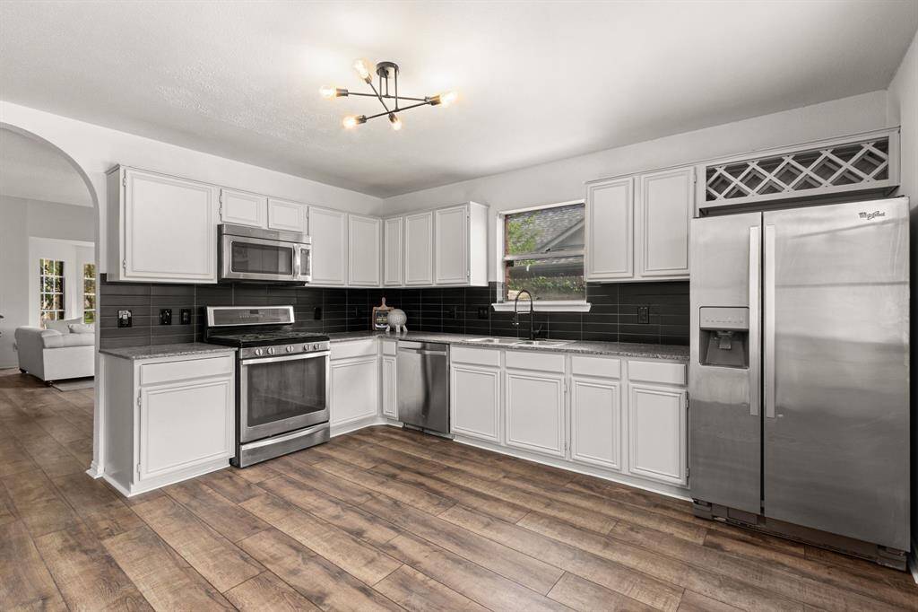 Granite kitchen with new, modern backsplash and Whirlpool stainless appliances