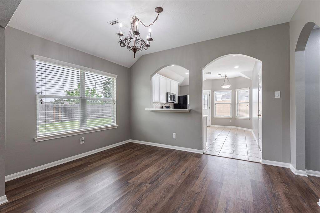 The kitchen entryway and hallway leading to the utility room and primary bedroom.