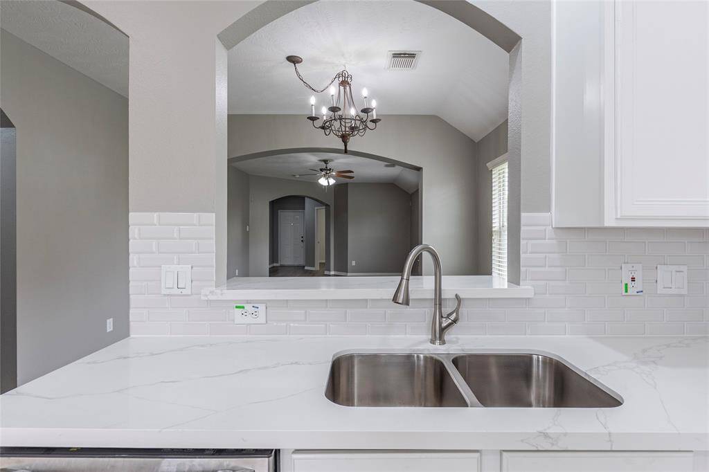 The kitchen has freshly painted cabinets and is open to the dining and living areas.