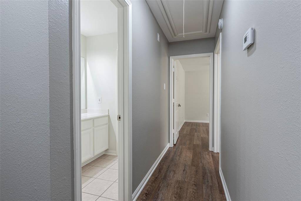 The hallway leading to secondary bathroom, and bedrooms two and three.