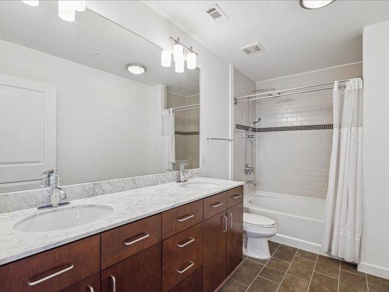 Primary ensuite bathroom with double vanity, upgraded with Grohe retro-fit shower system featuring deluxe bath shower head and a convenient handheld shower head for enhanced convenience and functionality.