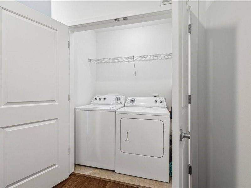 Spacious and functional laundry room featuring a full-size washer and dryer.