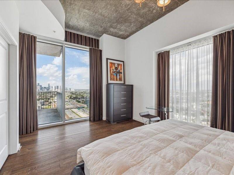 Enjoy breathtaking views from the primary bedroom, a unique retreat featuring a walk-in closet, custom drapes, elegant window coverings, and soaring 11-foot ceilings.