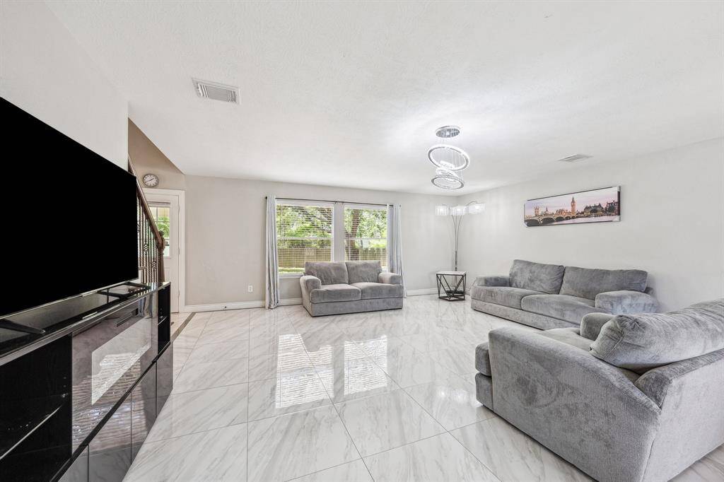 The living room area is spacious and can accommodate large gatherings.