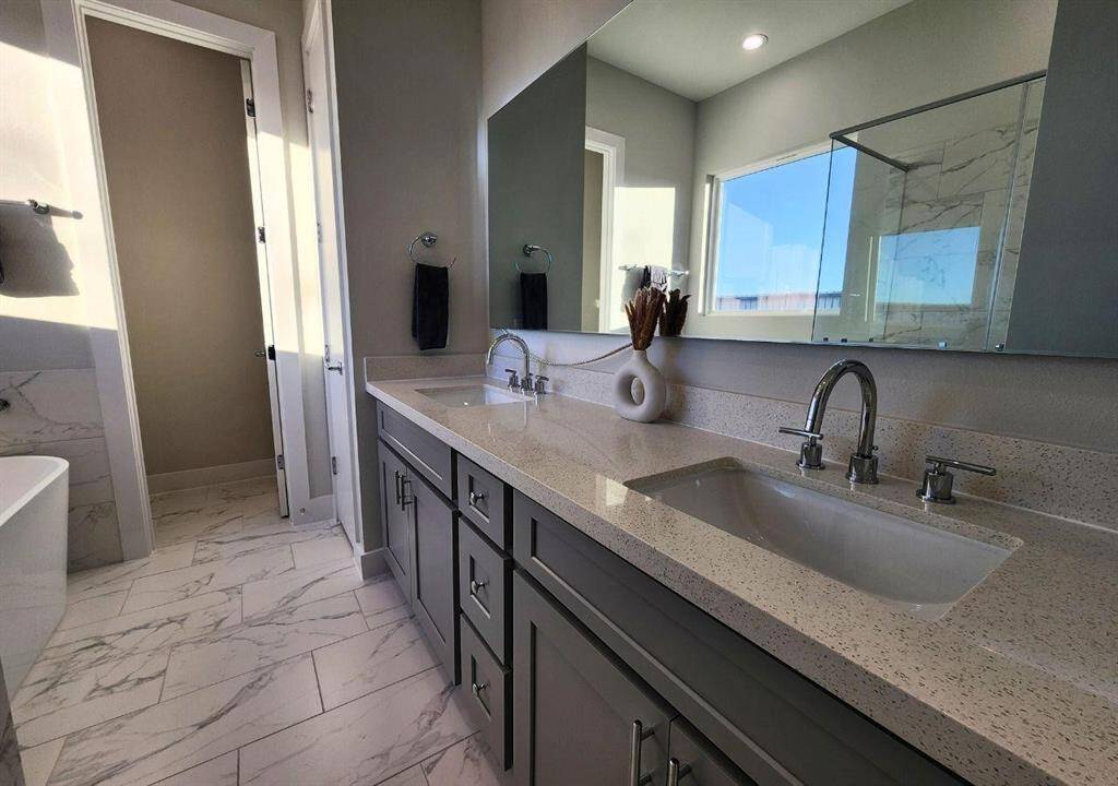 Beautiful double vanity and marble like floors accent this primary bath's retreat space.