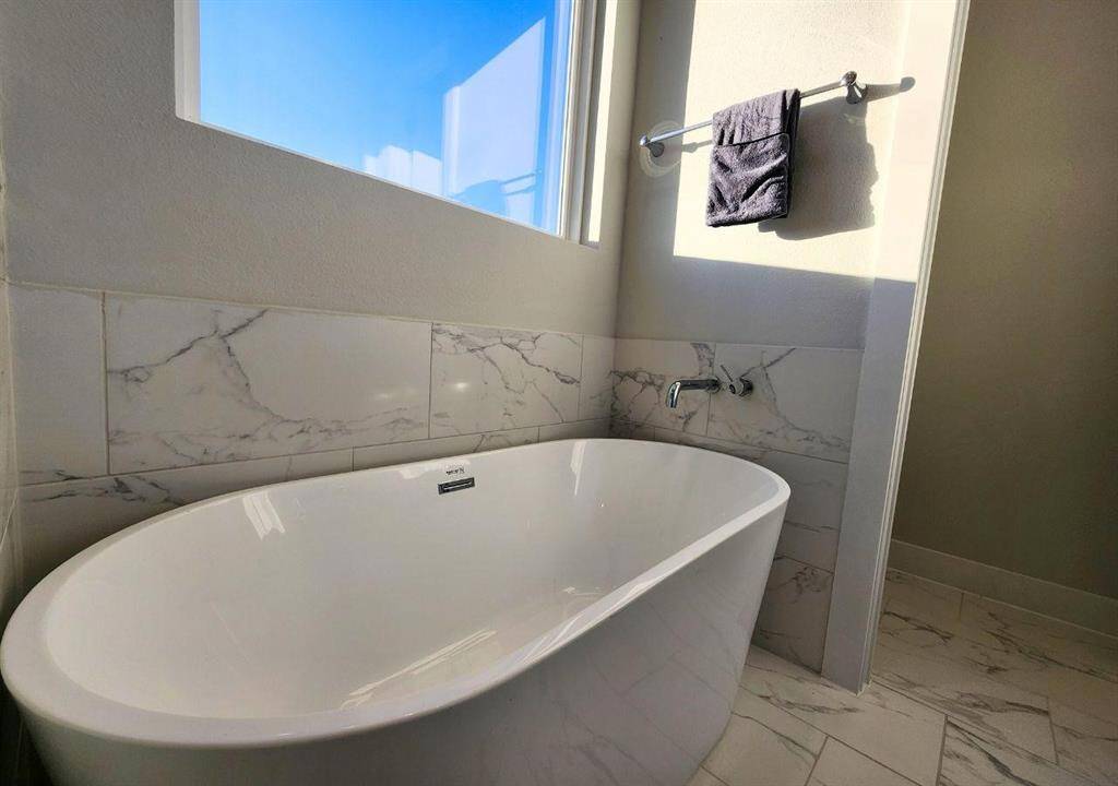 Gorgeous soaking tub sits off oif the separate shower and creates a spa like bathroom.