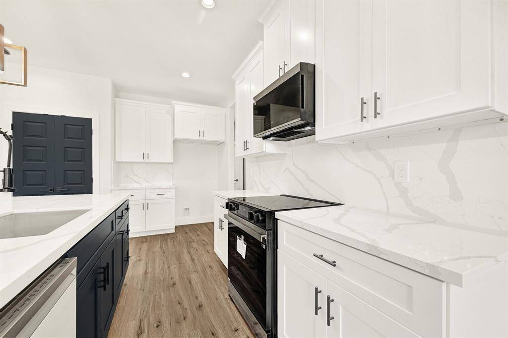 Large kitchen island with quartz counter top and decorative chandelier