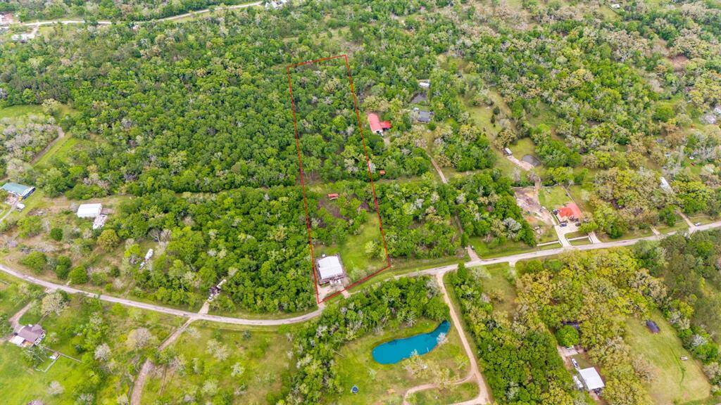 Stunning aerial view of this beautiful home nestled on 5 acres of serene land.