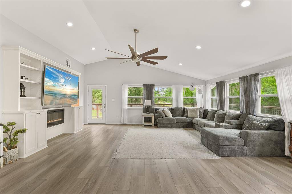 This inviting space is thoughtfully designed to provide both comfort and functionality, with its built-in shelves and a charming fireplace as the focal points.