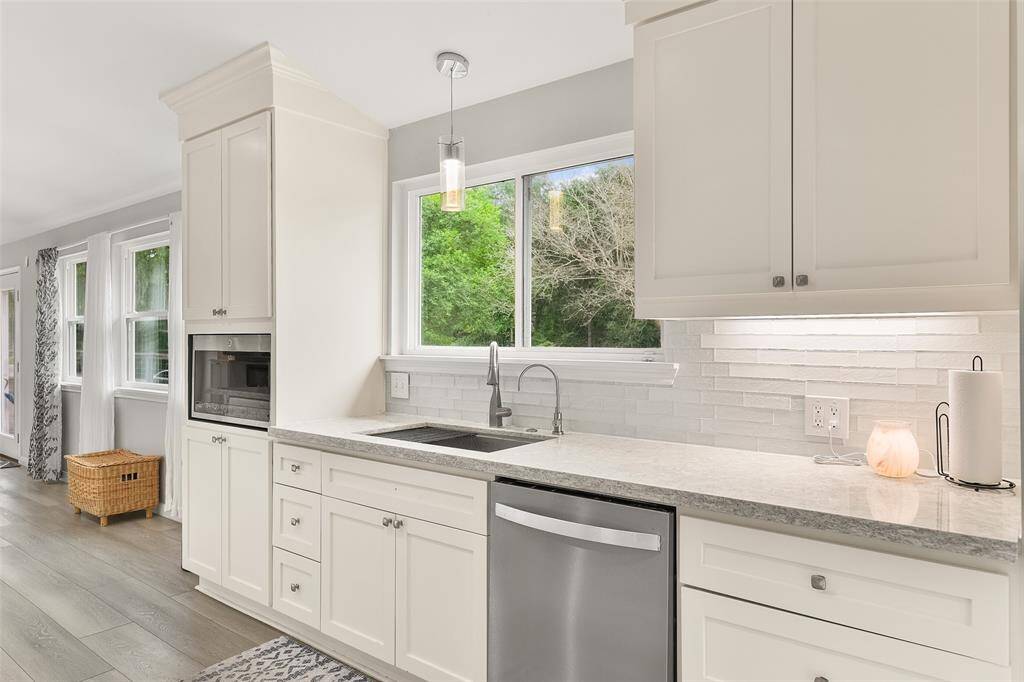 This delightful kitchen features a sink that looks out a window to the front of the home. As you stand at the sink, you can enjoy the beautiful scenery outside.